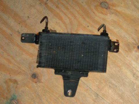 1994 Ford Bronco - Transmission cooler part shown against a wooden background.