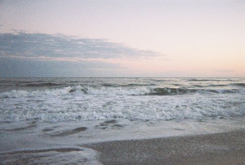 1991 Ford Probe - Waves roll onto the shore under a pastel sky, with the Supermotors logo visible.