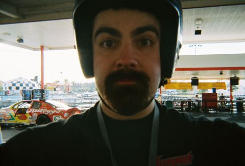 1991 Ford Probe - A person in a helmet is in the foreground, with a race car in the background.