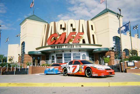 1991 Ford Probe - The NASCAR Cafe building is visible with two race cars parked outside.
