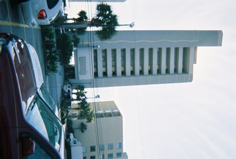 1991 Ford Probe - A red car is parked next to a white SUV in a parking lot with buildings in the background.
