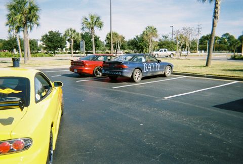 1991 Ford Probe - A blue sedan with 'BATN' scrawled on its side is parked in a lot.