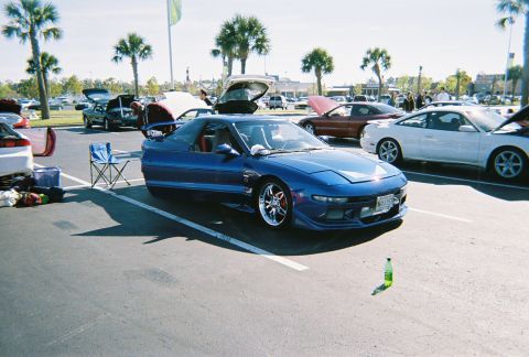 1991 Ford Probe - A blue 1991 Ford Probe is parked in a lot with other vehicles, some with hoods open.