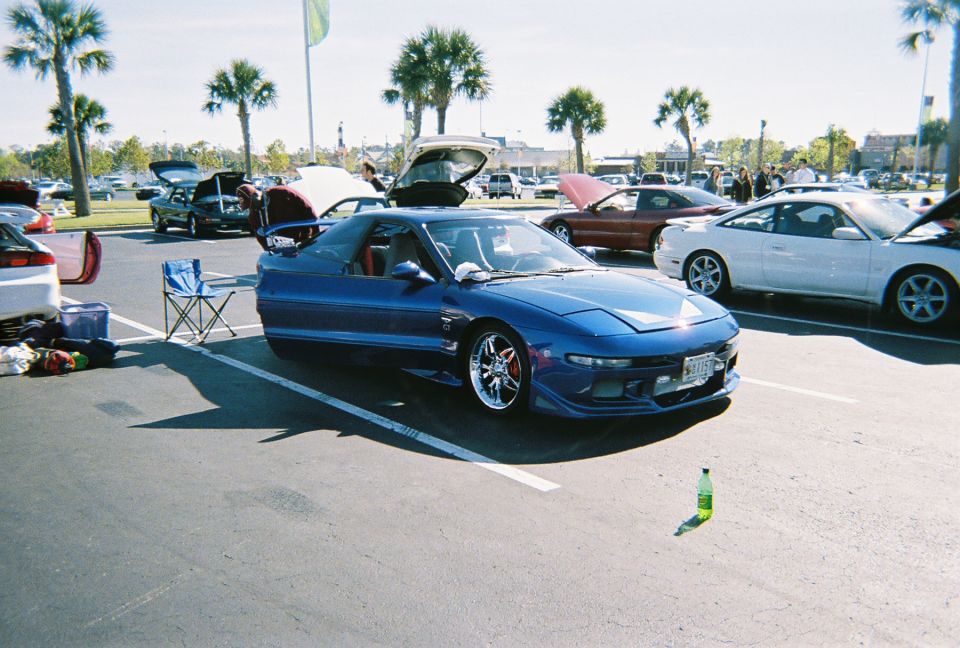 Blue 1991 Ford Probe with aftermarket wheels and body kit, parked in a lot