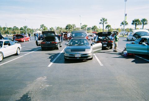 1991 Ford Probe - A gathering of Ford Probe vehicles in a parking lot on a sunny day.