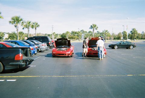 1991 Ford Probe - Cars gathered in a parking lot on a sunny day, with several vehicles on display.