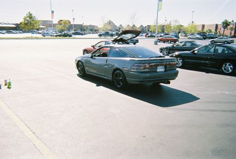 1991 Ford Probe - A gray coupe is parked in a lot with other vehicles and buildings in the background.