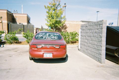 1991 Ford Probe - This red sedan has a message on its rear window stating 'MY OTHER CAR IS A PROBE'.