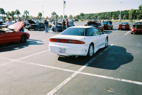 1991 Ford Probe - A white 1991 Ford Probe is parked in a lot with other vehicles.