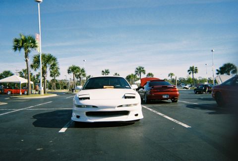 1991 Ford Probe - White 1991 Ford Probe with pop-up headlights in a parking lot with other cars.