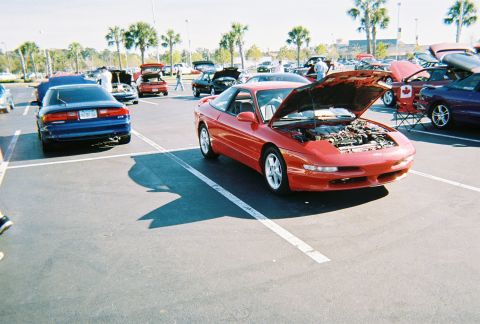 1991 Ford Probe - A red sports coupe is parked with its hood open, revealing the engine bay.