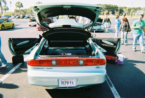 1991 Ford Probe - A light blue coupe is parked with its doors and trunk open, revealing subwoofers in the cargo area.