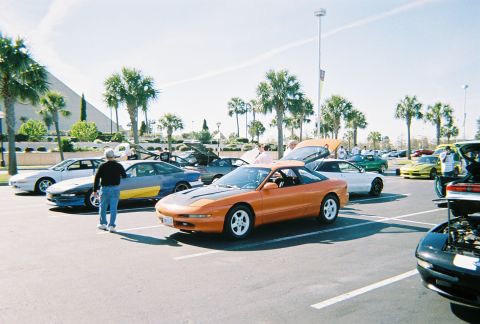 1991 Ford Probe - Several Ford Probes are gathered in a parking lot on a sunny day.