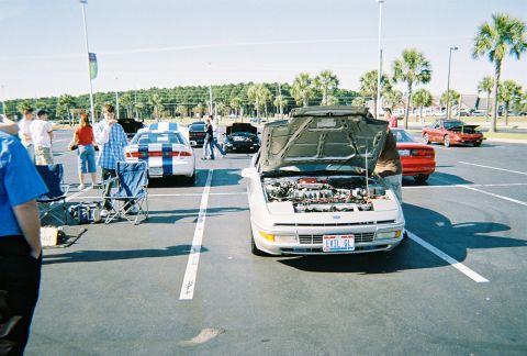 1991 Ford Probe - A silver 1991 Ford Probe is displayed with its hood open, revealing the engine and a custom license plate.
