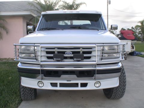 1993 Ford C-350 (Centurion Conversions) - Frontal view of a white Ford F-Series truck with a chrome grille guard and fog lights.