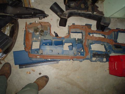 1984 Ford Bronco - The dashboard frame and some ducting parts are laid out on the floor, possibly for a rebuild or repair.