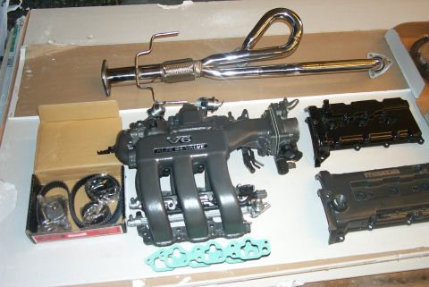 1996 Ford Probe - Engine components including an intake manifold, exhaust pipe, and valve covers are laid out on a surface.