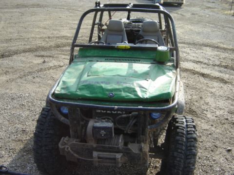1992 Ford Bronco - This green off-road buggy features a prominent roll cage and a front-mounted winch, seen from a head-on perspective.