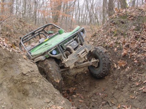 1992 Ford Bronco - This green off-road buggy navigates a challenging muddy terrain, its off-road capabilities.