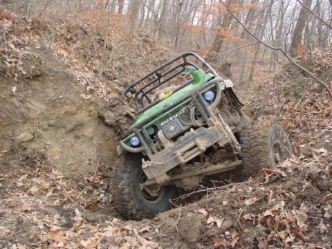 1992 Ford Bronco - This off-road vehicle is deeply embedded in mud on a steep, wooded slope.