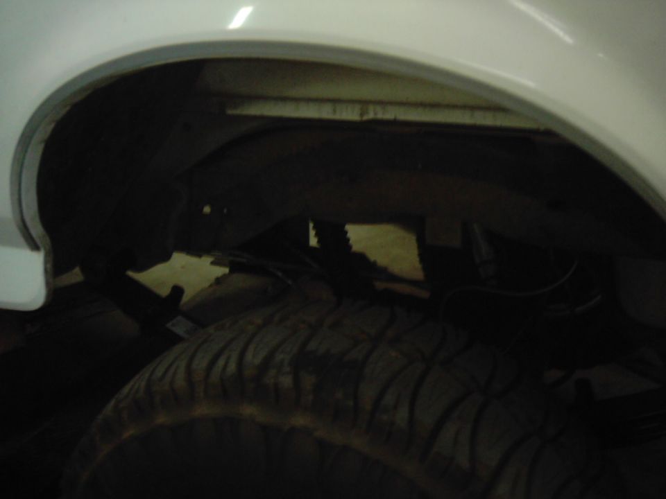 Close-up of a vehicle's rear wheel well and tire