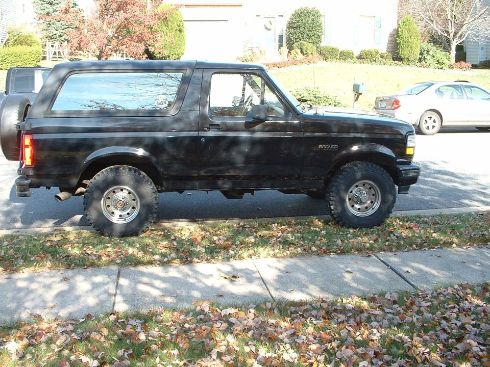 Side view of a black 1994 Ford Bronco parked on a residential street