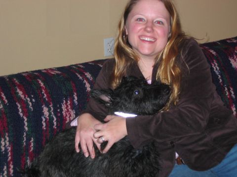 1985 Ford LTD Crown Victoria - A woman smiles while holding a black dog on a patterned couch.
