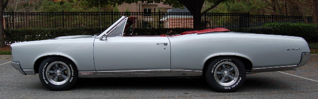 Silver convertible with red interior, side profile, top down