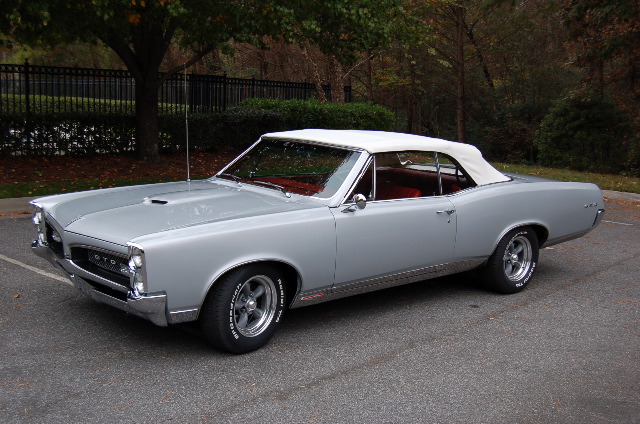 Silver Pontiac GTO convertible with white top and red interior, front 3/4 view