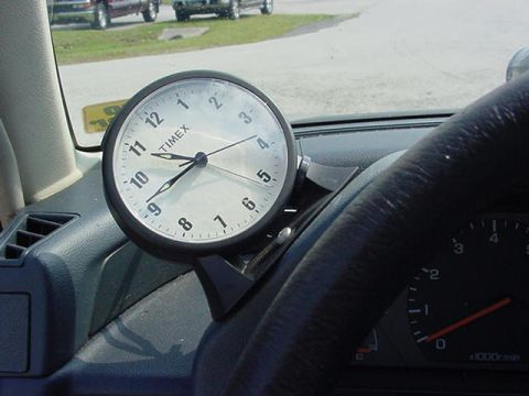 1996 Ford Probe - A Timex clock is visible on the dashboard of a vehicle, with other vehicles in the background.