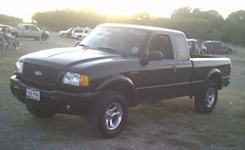 2002 Ford Ranger - A black 2002 Ford Ranger pickup truck is parked outdoors with other vehicles in the background.
