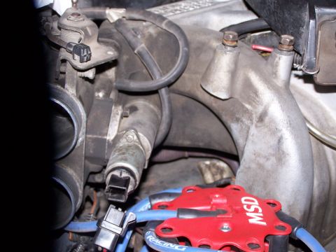 1986 Ford Bronco - Close-up of an engine's throttle body and MSD ignition components, likely during maintenance.