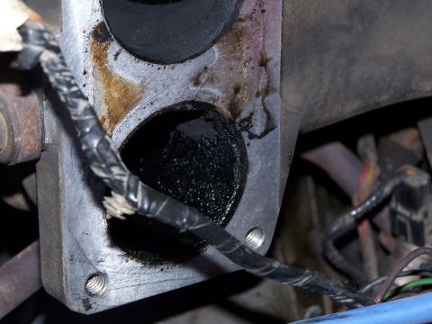 1986 Ford Bronco - This image shows a heavily carbon-fouled throttle body and intake manifold assembly with exposed wiring.