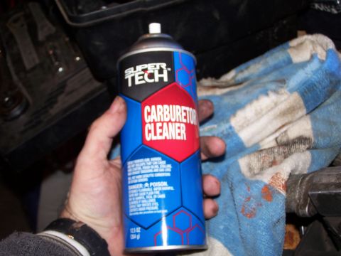 1986 Ford Bronco - A can of Super Tech carburetor cleaner is held in a hand, with a rag nearby.