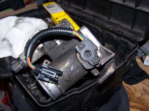 1986 Ford Bronco - A close-up view of a throttle body assembly, likely removed for cleaning or replacement.