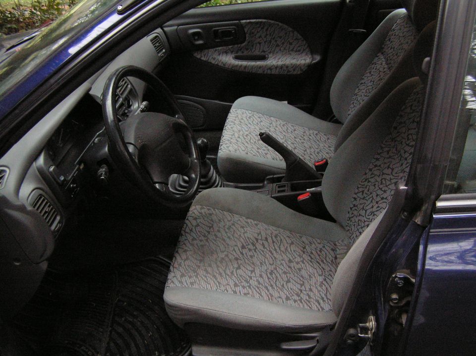 Gray cloth front seats and manual shifter in a blue Subaru interior