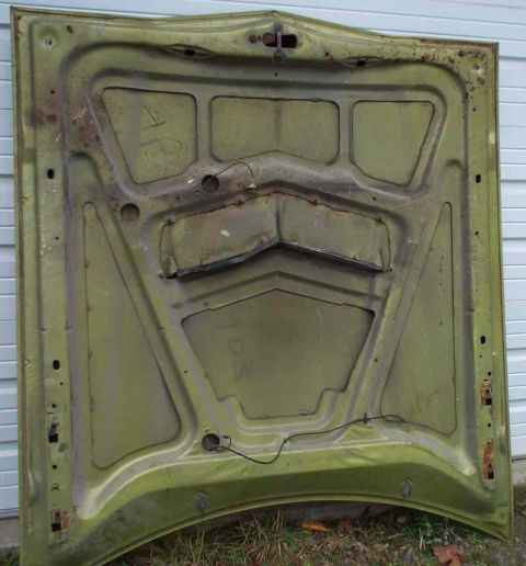 1970 Ford Torino - The underside of a green car hood shows signs of rust and some handwritten markings.