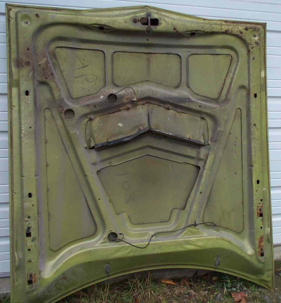 Underside of a green car hood with rust and handwritten numbers