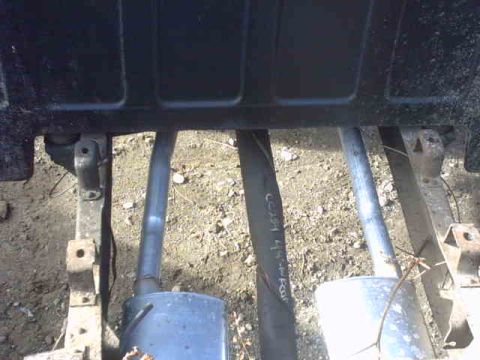 1995 Ford Bronco - Underside view of a vehicle's exhaust system, revealing mufflers and pipes attached to the frame.