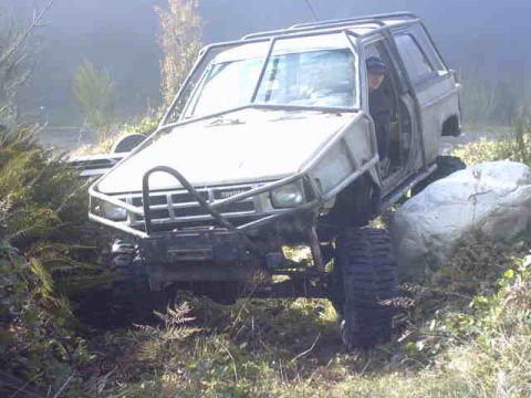 1995 Ford Bronco - This heavily modified off-road vehicle navigates a rocky terrain.