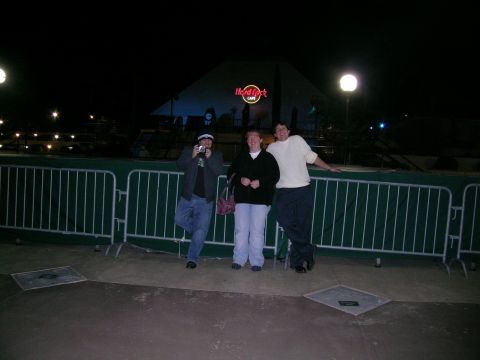 1993 Ford Probe - People pose for a photo outside a Hard Rock Cafe at night, with a green barrier in the foreground.