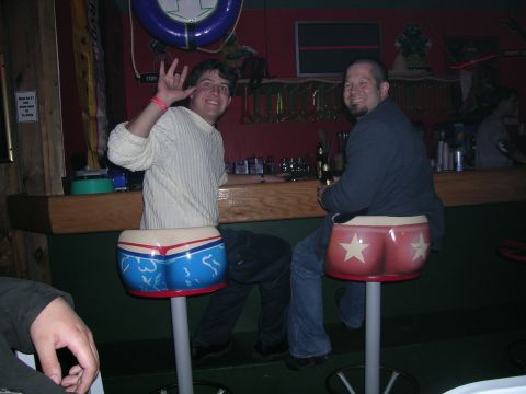 1993 Ford Probe - Two men are enjoying drinks at a bar, with one of them playfully waving at the camera.