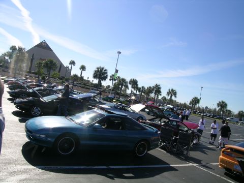 1993 Ford Probe - A teal 1993 Ford Probe is parked in a lot full of cars under a bright blue sky.
