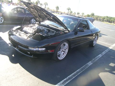 1993 Ford Probe - A black 1993 Ford Probe is parked with its hood open, revealing the engine bay.