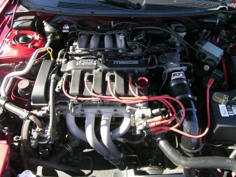 1993 Ford Probe - Close-up of a Mazda engine bay, red spark plug wires and an aftermarket intake system.