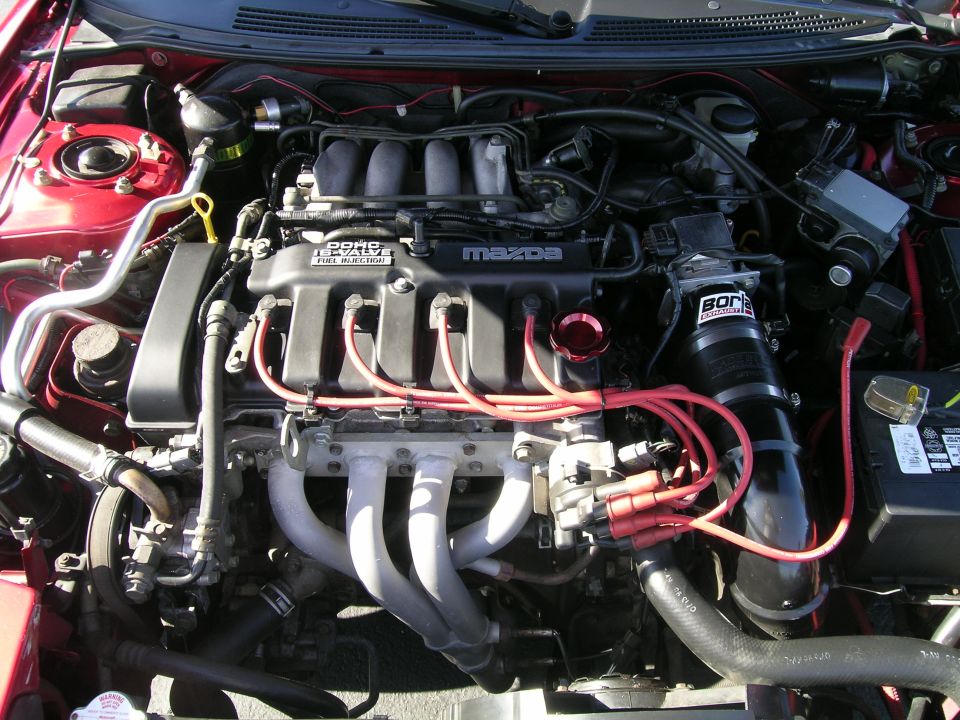 Mazda engine with red spark plug wires and a Borla intake