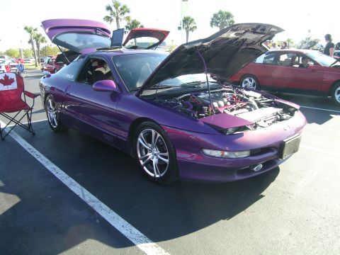 1993 Ford Probe - A purple Ford Probe is displayed with its hood and doors open, parked next to another vehicle.