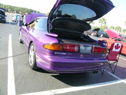 1993 Ford Probe - A purple 1993 Ford Probe GT is parked with its trunk and hood open, alongside other vehicles.