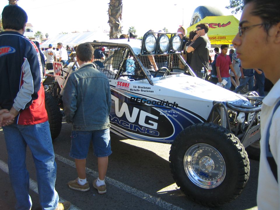 White and blue off-road buggy with WG Racing livery and roof light bar