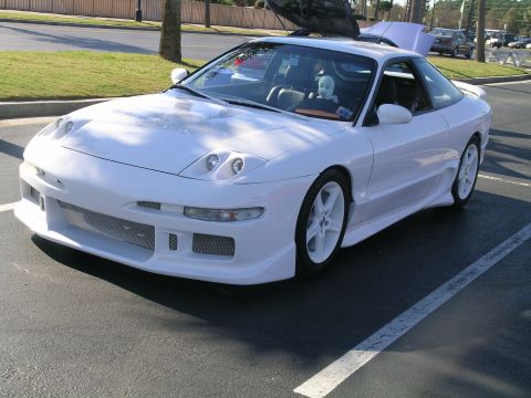 1993 Ford Probe - A white 1993 Ford Probe is parked in a lot, pop-up headlights and a custom body kit.